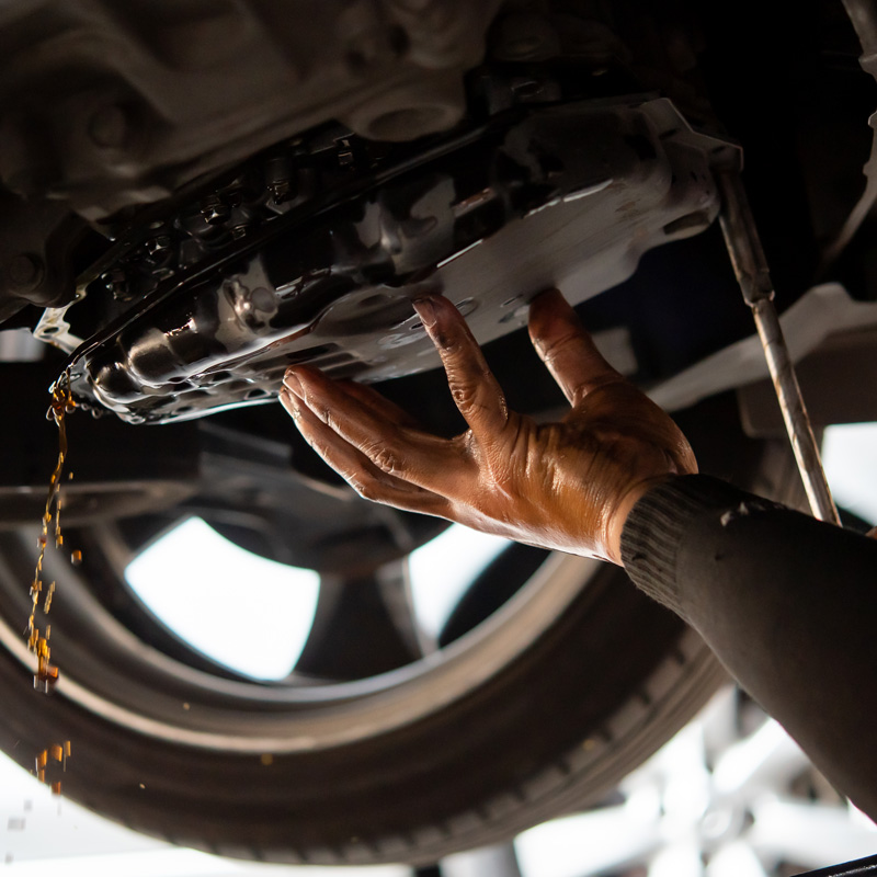 hand on an oil pan of a car