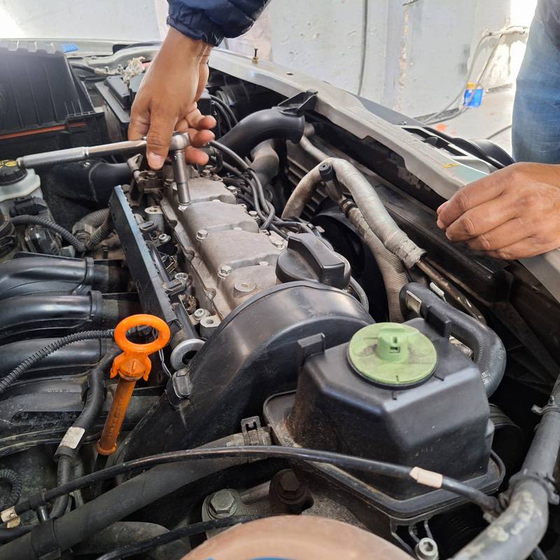 A mechanic working on a car engine with transmission repair being performed in Fort Lauderdale, FL