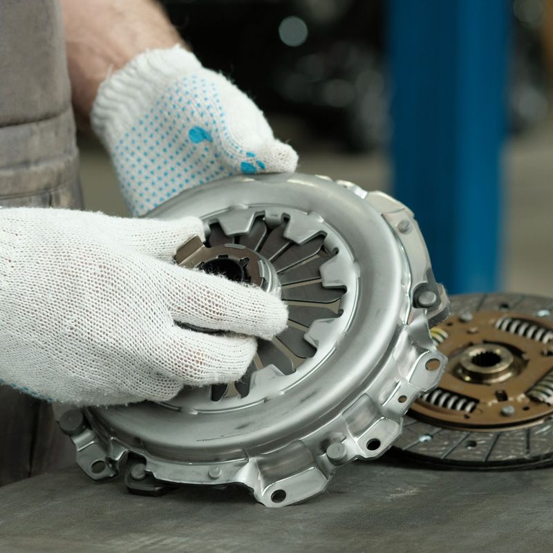 A mechanic handling a clutch pressure plate during clutch repair service in Fort Lauderdale, FL