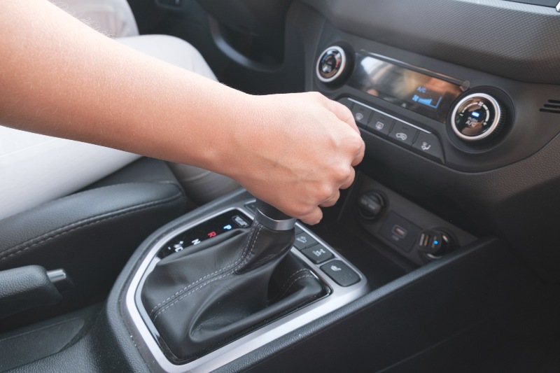 Driver shifting an automatic car transmission lever in Fort Lauderdale & Davie, FL